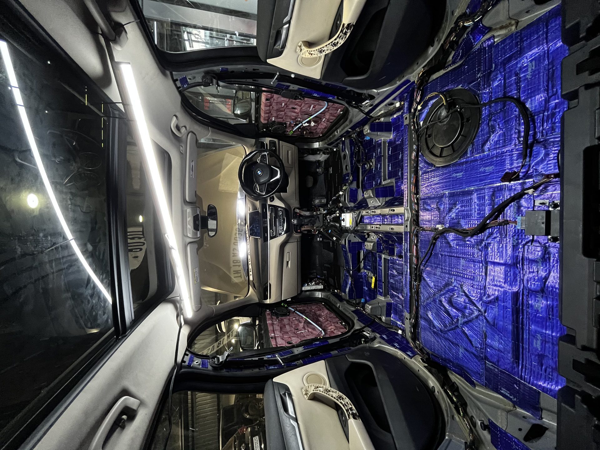 Car interior stripped — blue damping insulation installed